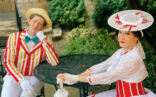 man and woman sitting at table dressed as Bert and Mary from Mary Poppins movie