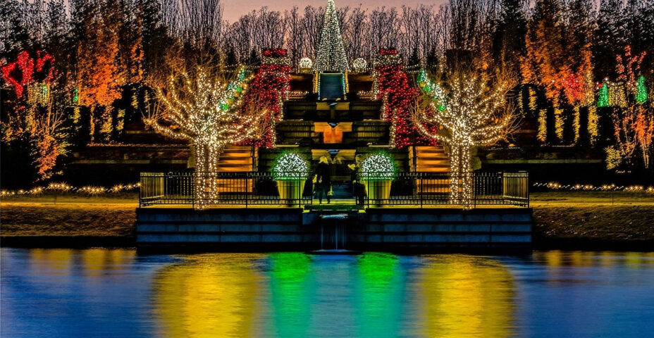 Garden terraces and trees lit for Botanic Garden of Lights, reflected in the lake at dusk